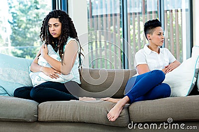 Unhappy lesbian couple sitting on sofa Stock Photo