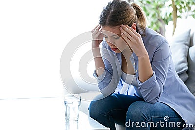Unhappy lonely depressed young woman sitting on sofa at home. Depression concept. Stock Photo
