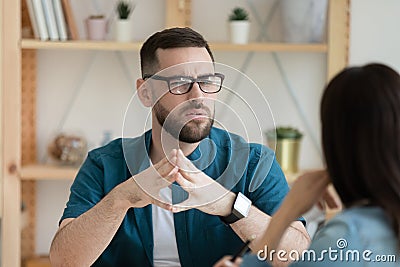 Unhappy male employee think talking with colleague at meeting Stock Photo