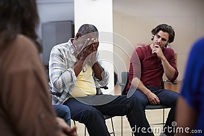 Unhappy Man Attending Self Help Therapy Group Meeting In Community Center Stock Photo