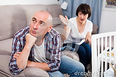 Unhappy mature man after quarrel, woman on background Stock Photo