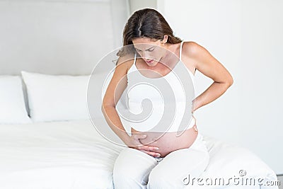 Unhappy pregnant woman suffering from back pain Stock Photo