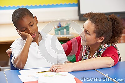 Unhappy Schoolboy Studying In Classroom Stock Photo