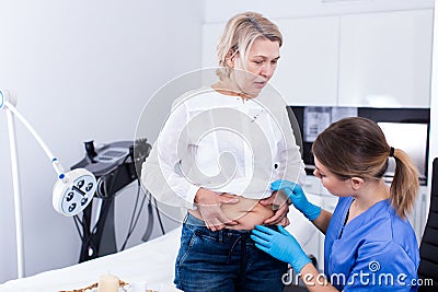 Unhappy senior lady attending aesthetic clinic Stock Photo