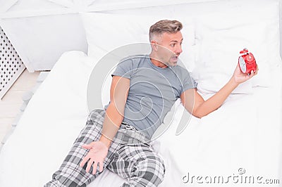 Unhappy shocked handsome man in bed. Man suffering headache. Terrible noise. Insomnia and sleep disorder. Daily routine Stock Photo