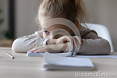 Unhappy small girl feel lazy studying at home Stock Photo