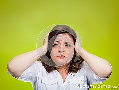 Unhappy stressed woman covering ears looking up Stock Photo