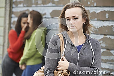 Unhappy Teenage Girl Being Gossiped About By Peers Stock Photo