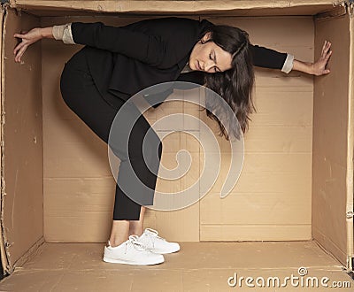 Unhappy unemployed business woman trying to increase her cramped office Stock Photo