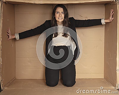 Unhappy unemployed business woman trying to increase her cramped office Stock Photo