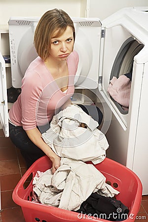 Unhappy Woman Doing Laundry Stock Photo