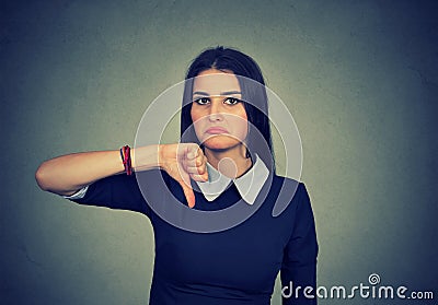 Unhappy woman giving thumb down gesture looking with disapproval Stock Photo