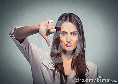 Unhappy woman giving thumb down gesture looking with negative expression Stock Photo