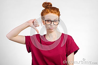 Unhappy woman giving thumbs down gesture looking with negative expression Stock Photo