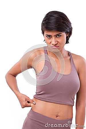 Unhappy woman with hand holding excessive belly fat Stock Photo
