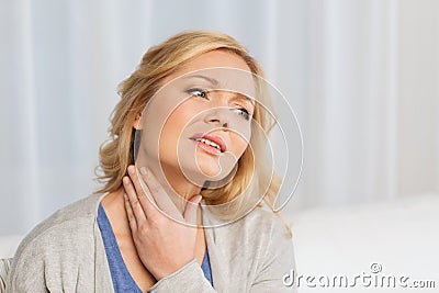 Unhappy woman suffering from throat pain at home Stock Photo