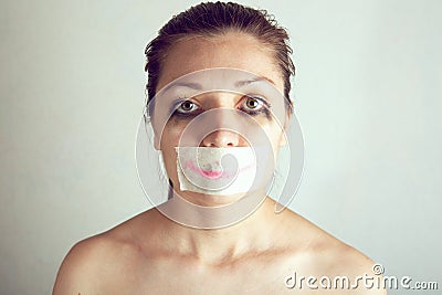 Unhappy woman with wrapping her mouth by adhesive tape painted smile Stock Photo