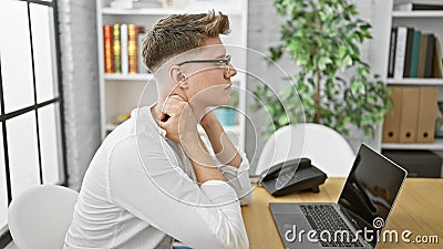 Unhappy young caucasian guy, a business professional, seriously suffering from neck pain at his office, work woes outpouring as he Stock Photo