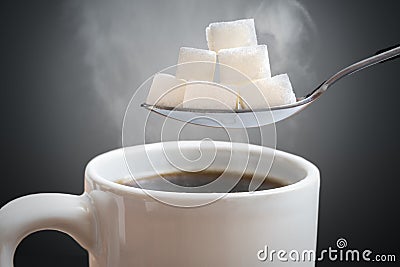 Unhealthy eating concept. Many sugar cubes above hot cup of tea or coffee Stock Photo