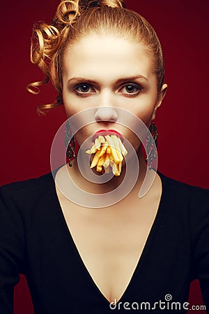 Unhealthy eating. Junk food concept. Arty portrait of woman with fries Stock Photo