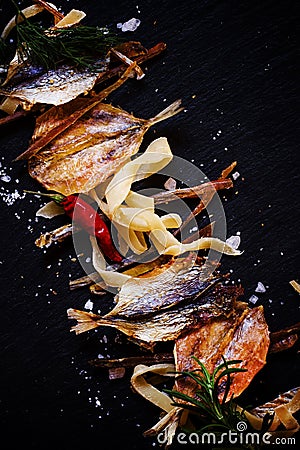 Unhealthy food background: dried fish, smoked squid, spices. Sal Stock Photo