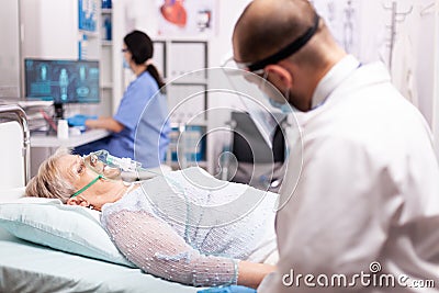 Unhealthy old woman with respiratory infection wearing oxygen mask Stock Photo