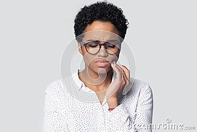 Unhealthy upset millennial ethnic woman suffering from strong tooth ache. Stock Photo