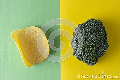 Unhealthy versus healthy food. Choise concept. Potatoe chips or broccoli. Top view, colorful background Stock Photo