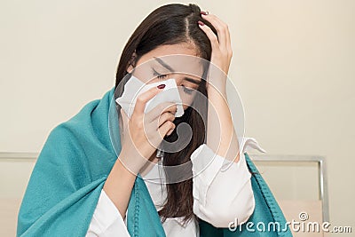 Unhealthy young female have cold and high temperature from fever and sitting on the bed Stock Photo