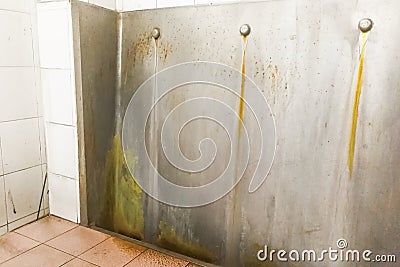 Unhygienic dirty urinal with limescale stain built up Stock Photo