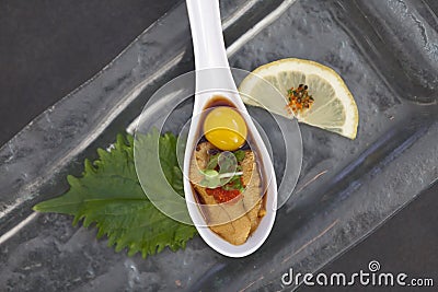 Uni Sushi on Spoon with Quail Egg Stock Photo