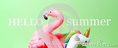 Unicorn, flamingo and pineapple swim tube on green background. Inflatable unicorn, flamingo and pineapple Stock Photo