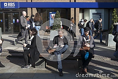 Unidentifed men reads a book on a bench with tourists in background. More than 15 million people visit London each year. Editorial Stock Photo