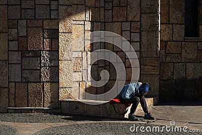 Unidentifiable poor child sits alone, sad and desperate Stock Photo