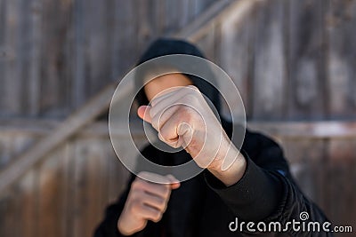 Unidentifiable teenage boy attacking with hes bare hands, focus on the fist Stock Photo