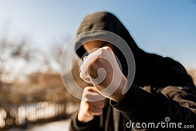 Unidentifiable teenage boy attacking with hes bare hands, focus on the fist Stock Photo