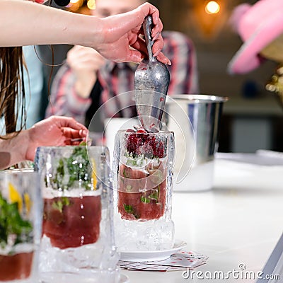 Unidentified barman adding berries smoothie in an ice glass on t Stock Photo