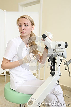 Unidentified doctor blond young make microscopic investigation Editorial Stock Photo