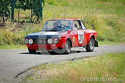 Unidentified drivers on a black and red vintage Lancia Fulvia racing car Editorial Stock Photo