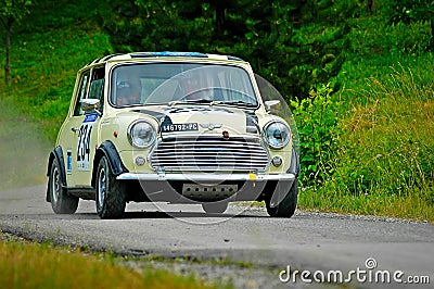 Unidentified drivers on a yellow vintage Mini Cooper racing car Editorial Stock Photo