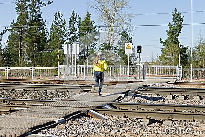 Unidentified girl running railways at a pedestrian crossing on a green traffic light signal Editorial Stock Photo