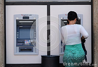 Unidentified girl withdrawing money from an ATM machine Editorial Stock Photo