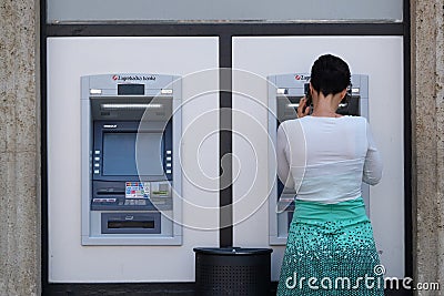 Unidentified girl withdrawing money from an ATM machine Editorial Stock Photo