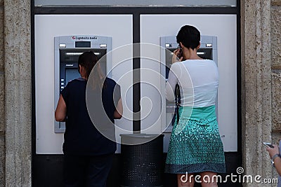 Unidentified girl withdrawing money from an ATM machine Editorial Stock Photo