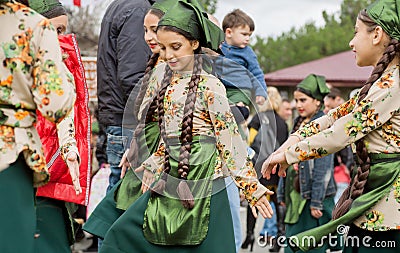 Unidentified girls dancing in crowd of people in traditional costumes during the party Editorial Stock Photo