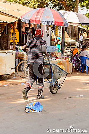 Unidentified local man pulls a cart in a village in Guinea Biss Editorial Stock Photo