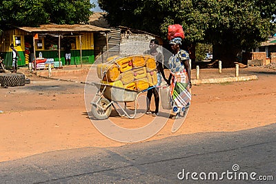 Unidentified local woman pulls a cart with jerrycans in a villa Editorial Stock Photo