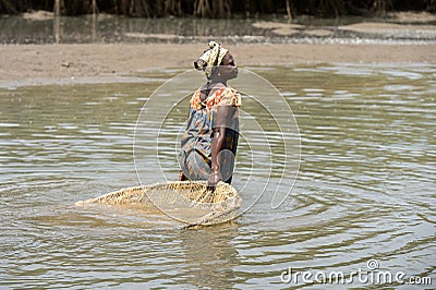 Unidentified local woman pulls a fishing net in the water in a Editorial Stock Photo
