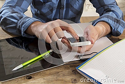 Unidentified man close up hands using mobile phone working busy with notepad and digital tablet pad computer Stock Photo
