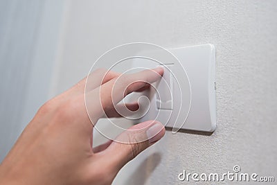Unidentified man hand with finger on light switch turn on turn off lights. Stock Photo